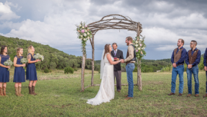 bride and groom under a wooden huppah