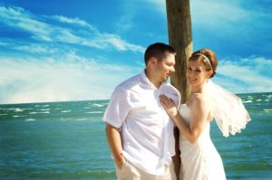 smiling bride and groom at the beach