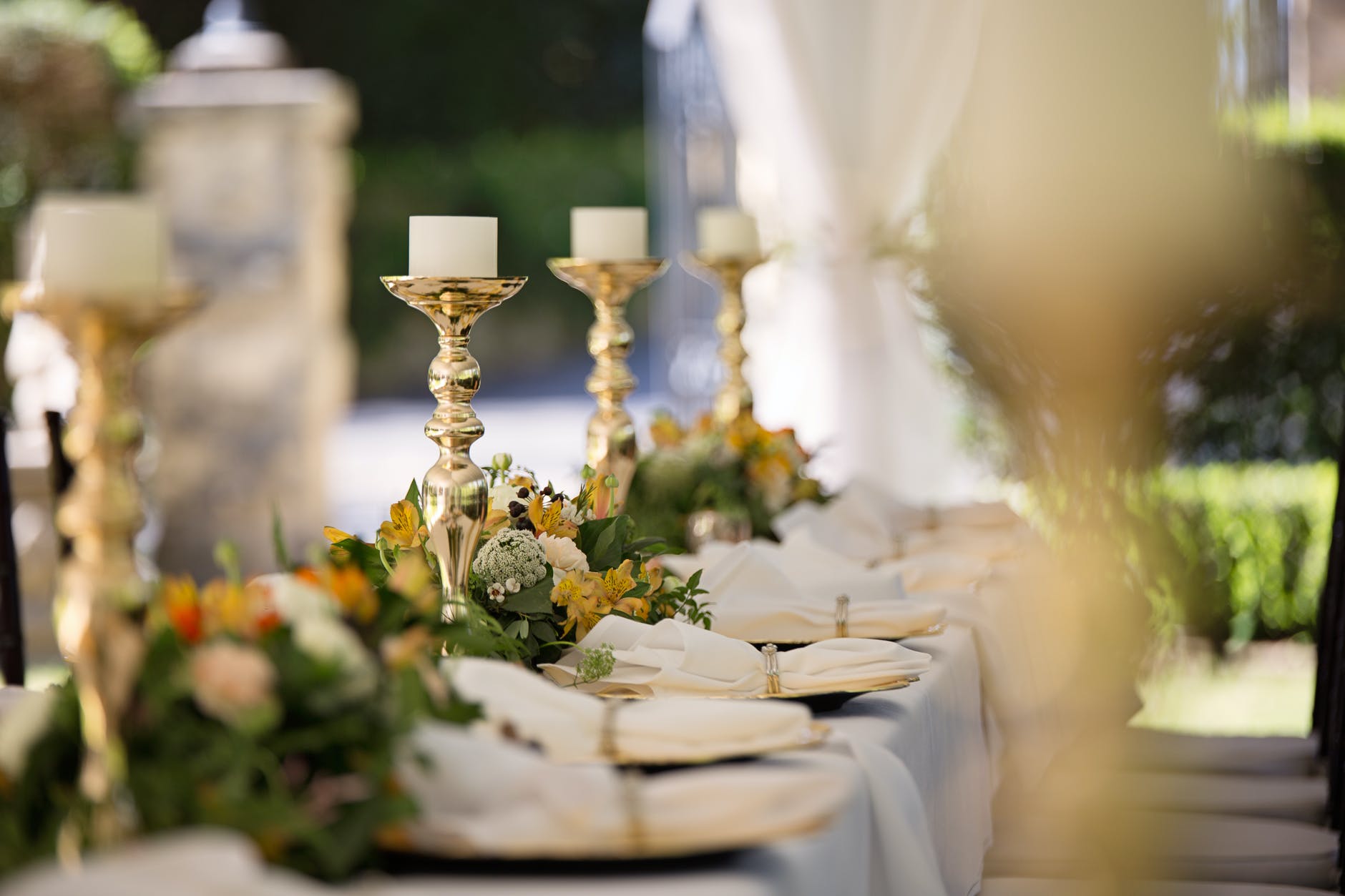 long table with flowers, linens and plates in outdoor wedding