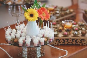 wooden table with mini appetizers and flowers displayed