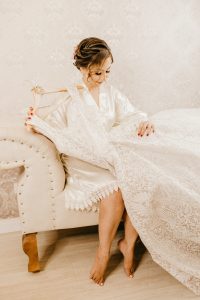 bride in robe holding wedding dress